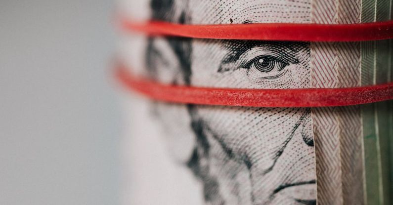 Exchange Programs - Closeup of rolled United States five dollar bills tightened with red rubber band